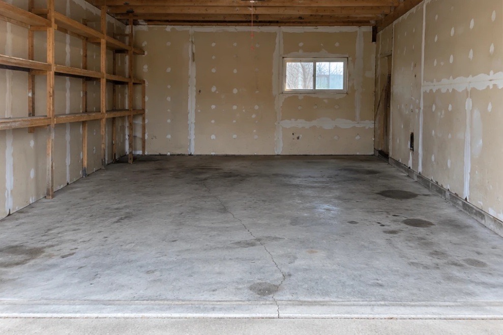 The same garage emptied, with bare shelves and a clear concrete floor